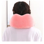 Person wearing a pink neck pillow against a white background